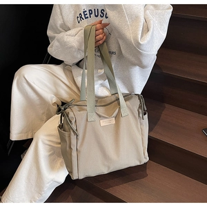 Dettaglio della borsa tote in nylon beige con toppa in pelle e tasca laterale