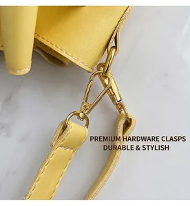 Detail of yellow pebbled leather handbag with golden metal lobster clasp and strap stitching