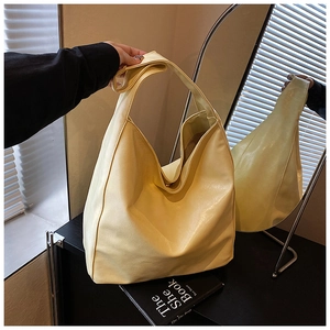 Detail of light yellow hobo tote bag in synthetic leather with elegant draped structure