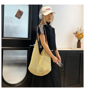 Detail of hollow woven beach tote bag with brown leather strap for summer vacation