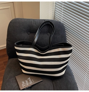 Close-up of black and white striped knitted tote bag on a chair with soft lighting