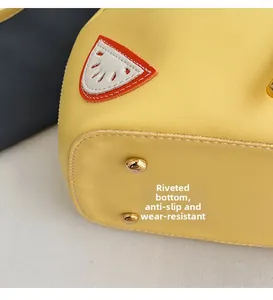 Detail of yellow leather handbag base with protective gold metal studs for wear resistance