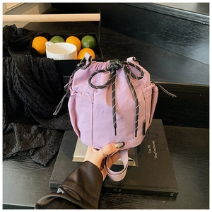 Detail of purple nylon bucket bag with drawstring closure and side mesh pocket