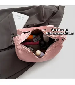 Macro shot of the spacious interior of a pink leather tote with a brand pocket
