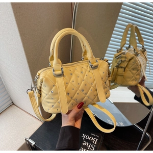 Detail of light yellow quilted Boston bag featuring sparkling rhinestone embellishments