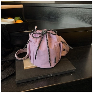 Detailed view of purple drawstring bucket bag with side mesh pockets and patterned rope