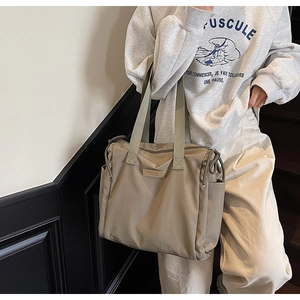 Dettaglio borsa tote kaki capiente con coulisse laterale e toppa con logo