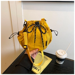 Detail of yellow nylon drawstring bucket bag with mesh side pocket and checkered strap
