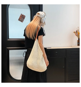Detail of white hollow woven tote bag with brown leather shoulder strap for summer beach