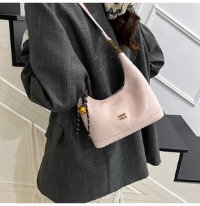 Dettaglio della borsa hobo in pelle rosa chiaro con logo dorato e finitura lucida