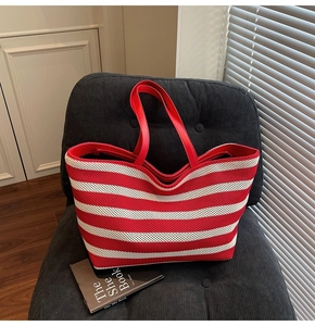 Macro view of a large capacity red and white striped woven tote bag with red handles