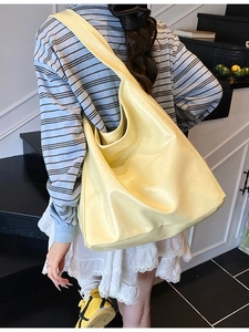 Minimalist large capacity pale yellow PU leather tote bag shown on a model's shoulder