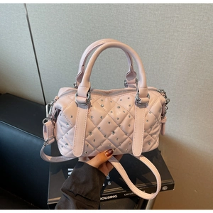 Detail of pink quilted handbag with crystals and silver hardware in hand view