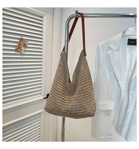 Detail of hand-woven hollow knit tote with leather strap and metal rivets on hanger