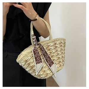 Detail of woven straw handbag featuring a decorative bear print silk scarf and top handle