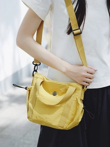 Minimalist bright yellow nylon crossbody bag with side drawstring and adjustable strap