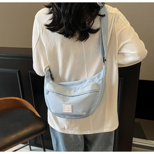 Gros plan du sac bandoulière croissant bleu clair avec bandoulière réglable