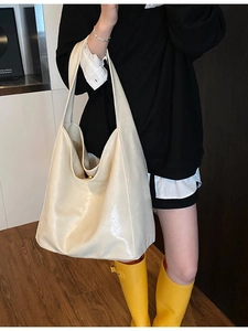 Minimalist cream white leather large tote bag shown on model in a stylish interior setting