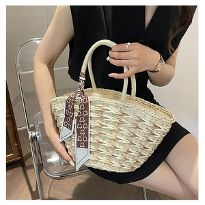 Detail of hand-woven straw tote bag with brown bear pattern scarf and inner drawstring bag
