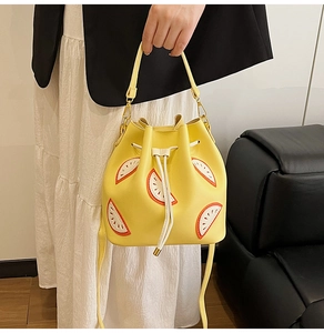Detailed view of yellow bucket bag featuring a watermelon patch and drawstring closure