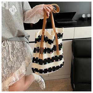 Détail du sac cabas en tricot rayé avec perles colorées et poignée en cuir marron