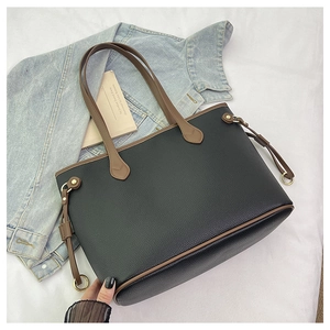 Close-up of litchi grain leather tote bag with brown handles and gold hardware details