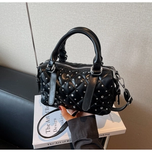 Detailed view of black quilted leather bucket bag with silver studs and top handle