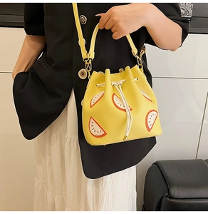 Detail of fashion yellow bucket bag with summer fruit embroidery and adjustable shoulder strap