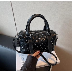 Detail of black quilted Boston bag featuring sparkling rhinestones and silver hardware