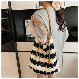 Détail du sac cabas en maille rayée avec perles fantaisie et anses en cuir marron