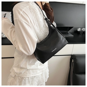 Close-up of black lychee grain dumpling bag with silver zipper and white fashion logo