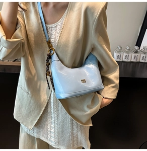 Dettaglio della borsa a tracolla in pelle azzurra con corda intrecciata marrone e fibbia oro