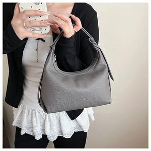 Detail view of the gray litchi texture leather dumpling bag with brand logo engraving