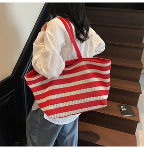 Detail of red and white striped knit tote bag with durable faux leather shoulder straps