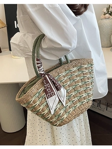 Handwoven straw tote bag in beige and green with patterned scarf and top handles