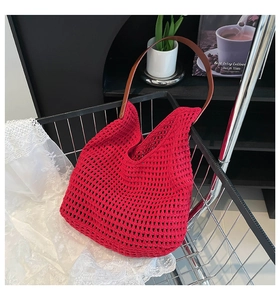 Close-up of red crochet woven tote bag with hollow mesh design and brown leather strap
