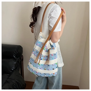 Détail du sac cabas tricoté à rayures bleu et crème avec perles et anses en cuir