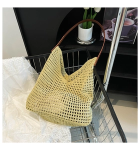 Detail of hollow woven beach tote bag with premium brown leather strap on lace cloth