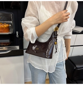 Dettaglio borsa in pelle cerata testa di moro con pieghe eleganti e finiture dorate lucide