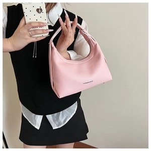Detail of pink lychee leather crescent bag with Fashion & Bags text and smooth zipper
