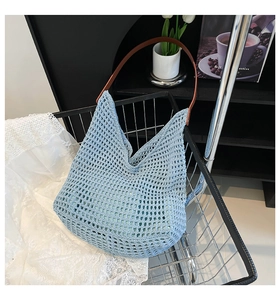 Light blue knit crochet tote bag inside a shopping cart with rustic aesthetic decor