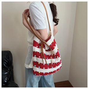 Vue détaillée du sac cabas en tricot rayé avec perles colorées et bandoulière en cuir