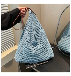 Detail of light blue woven hollow tote bag with premium dark brown leather handles
