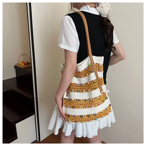 Détail du sac cabas rayé tissé main avec des perles colorées et une bandoulière en cuir