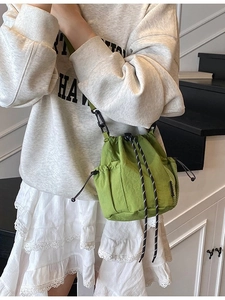 Green nylon mini bucket bag with drawstring and adjustable strap for sports