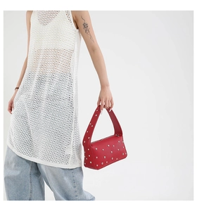 Dettaglio borsa punk rossa in pelle con borchie argentate e ampio manico strutturato