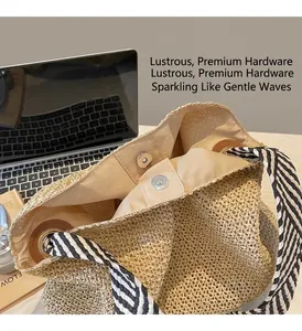 Detail of metal magnetic buckle and striped fabric strap on a beige straw tote bag
