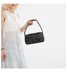 Dettaglio della borsa a tracolla in pelle nera con eleganti borchie metalliche argentate