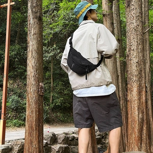 Close-up of a durable black nylon crossbody chest bag for outdoor hiking and leisure