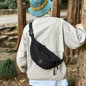 Close-up of black nylon crescent chest bag with adjustable strap and quick-release buckle